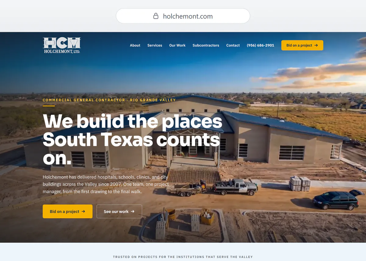 Holchemont's new homepage: the headline We build the places South Texas counts on. over video of the same blue-roofed building under construction, with a gold Bid on a project button in the navigation and again beside a See our work button in the hero.